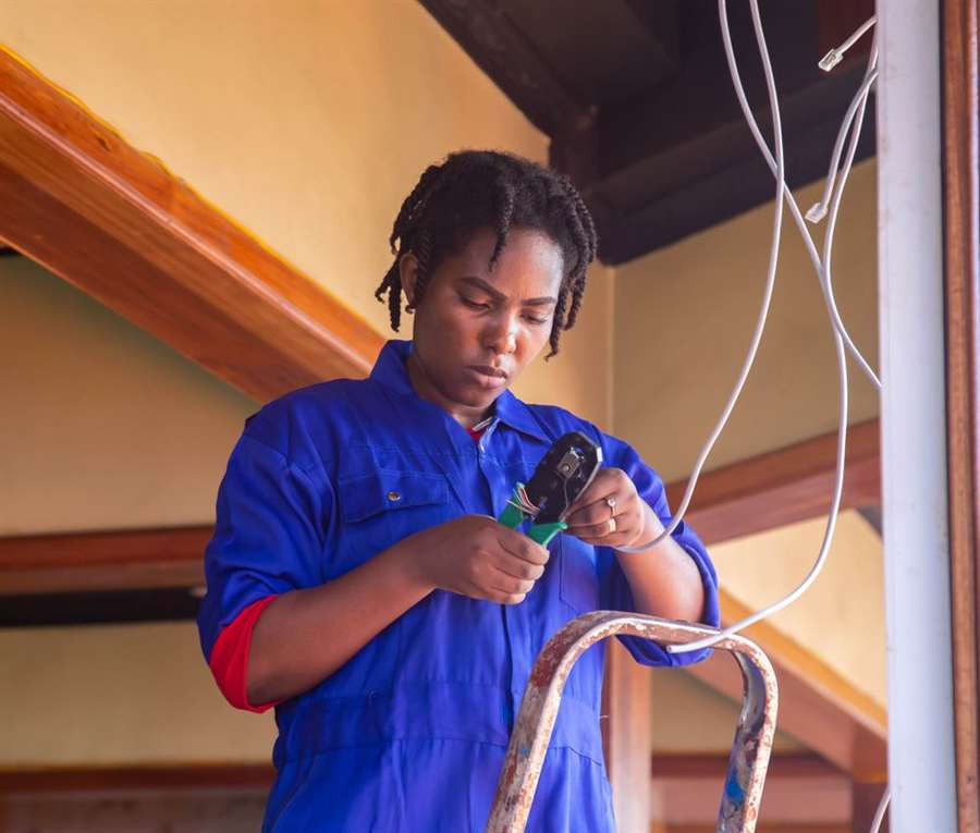 Electrician on a ladder running cable