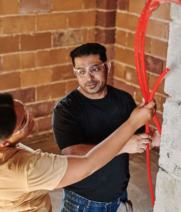Workers running conduit in a commercial space