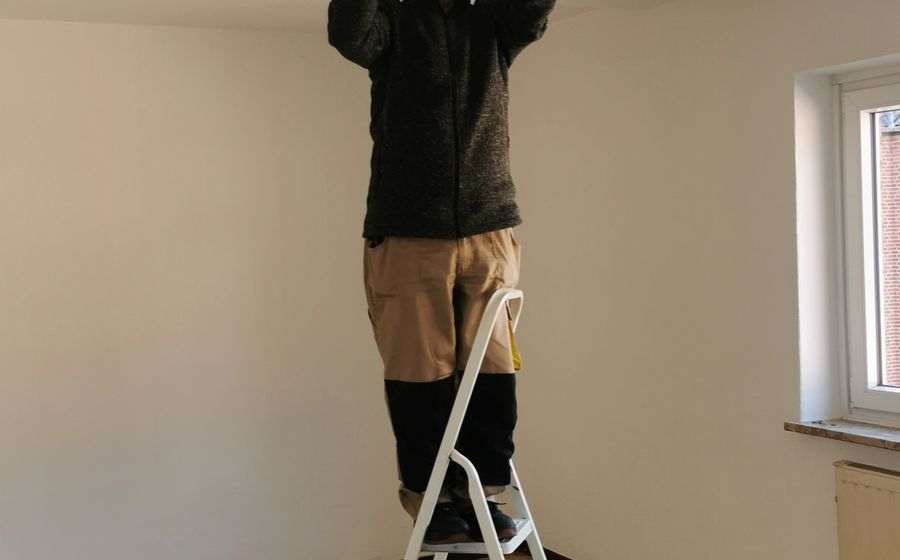 Electrician fitting a ceiling light