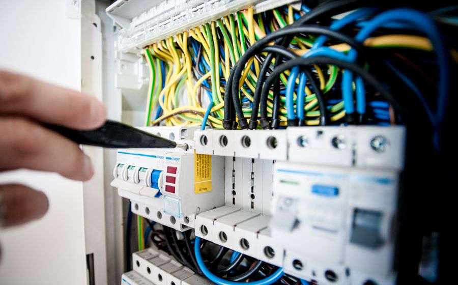 Hands working on a circuit breaker panel